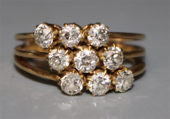 A gold and nine stone diamond set triple shank ring, size K.